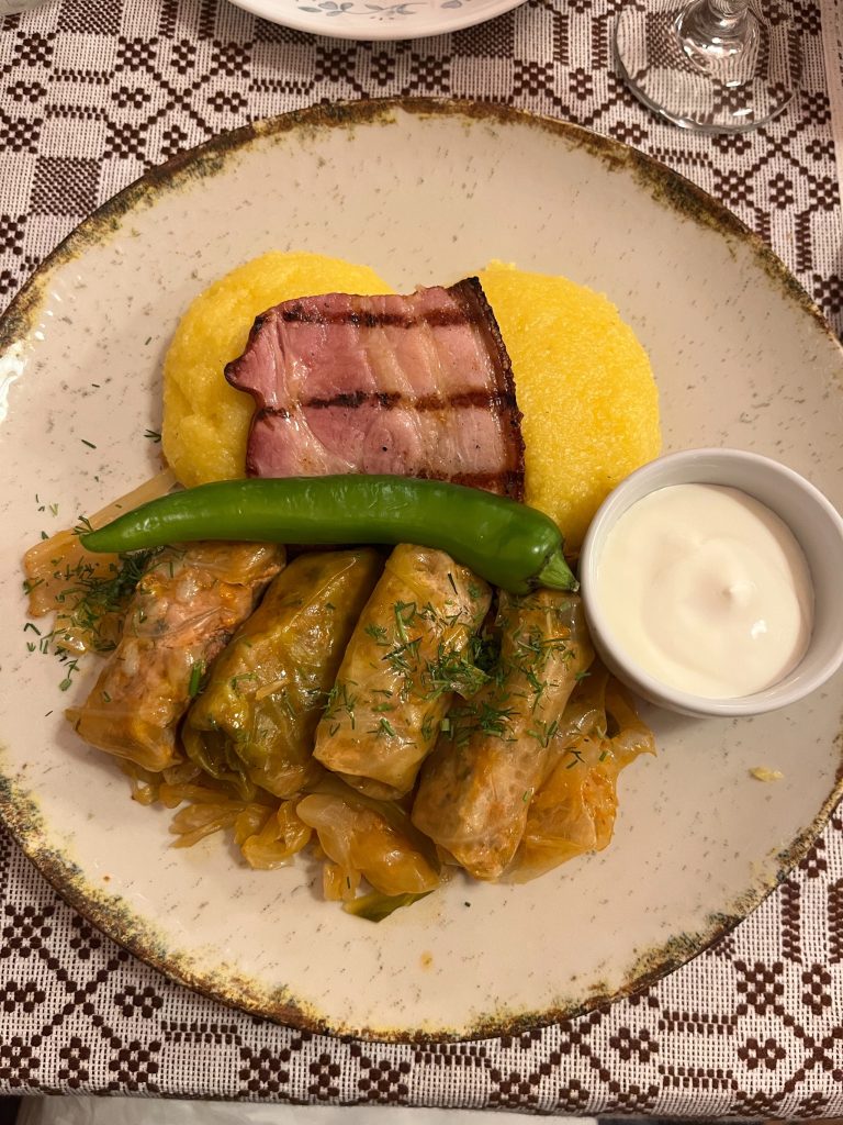 Sarmale- Romanian trad dish - minced meat rolls in cabbage leaves dressed w/bacon and polenta w/sour cream